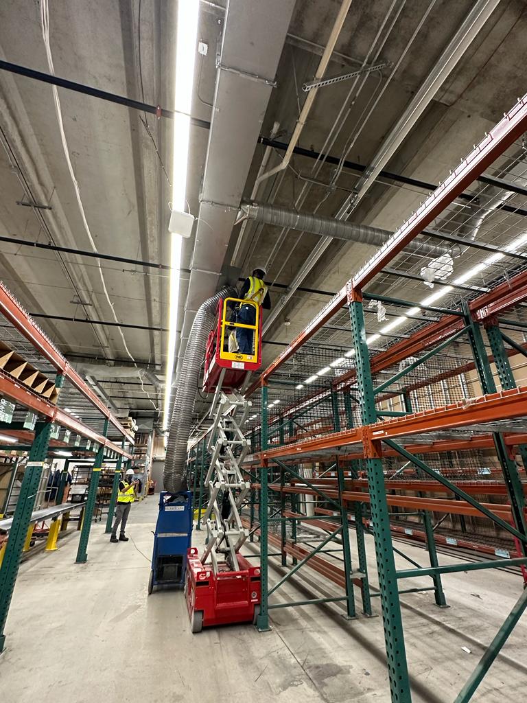 Pallet-rack warehouse — overhead spiral duct cleaning between aisles