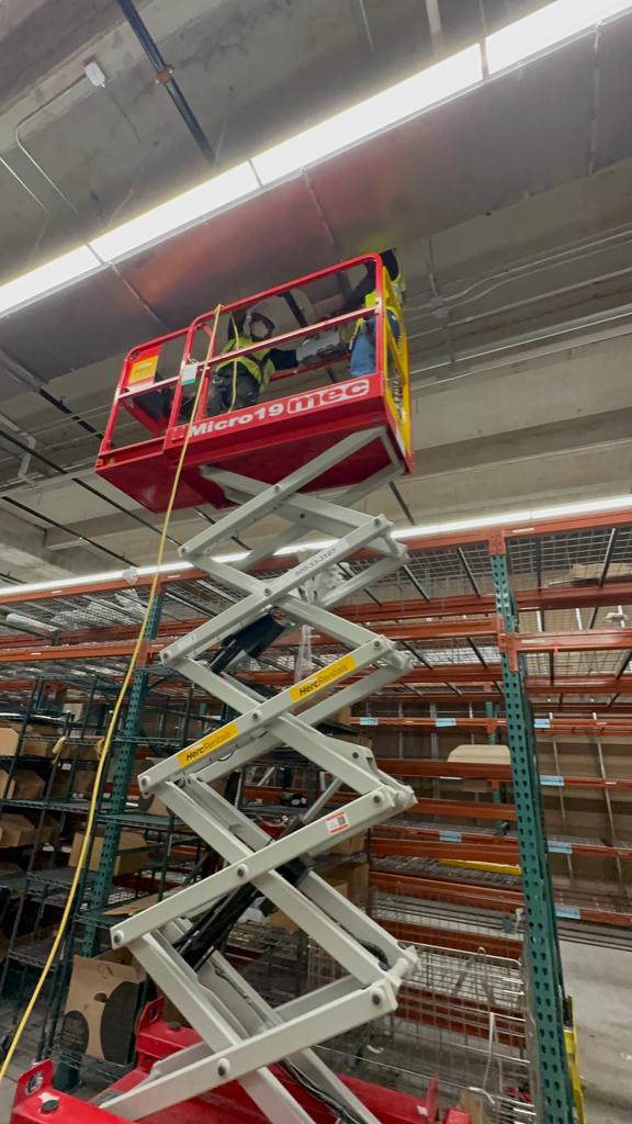 Warehouse mezzanine — high-bay duct access above pallet racks
