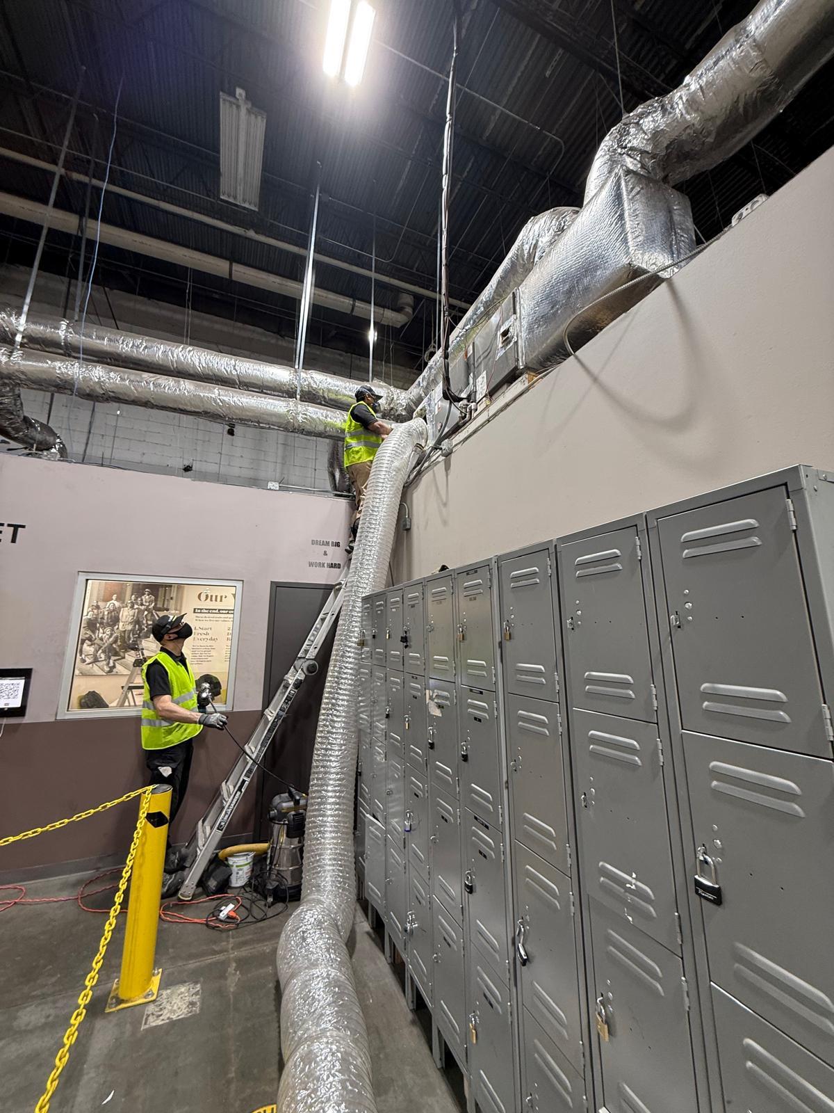 Plant locker room — overhead trunk and branch duct cleaning with negative-air containment