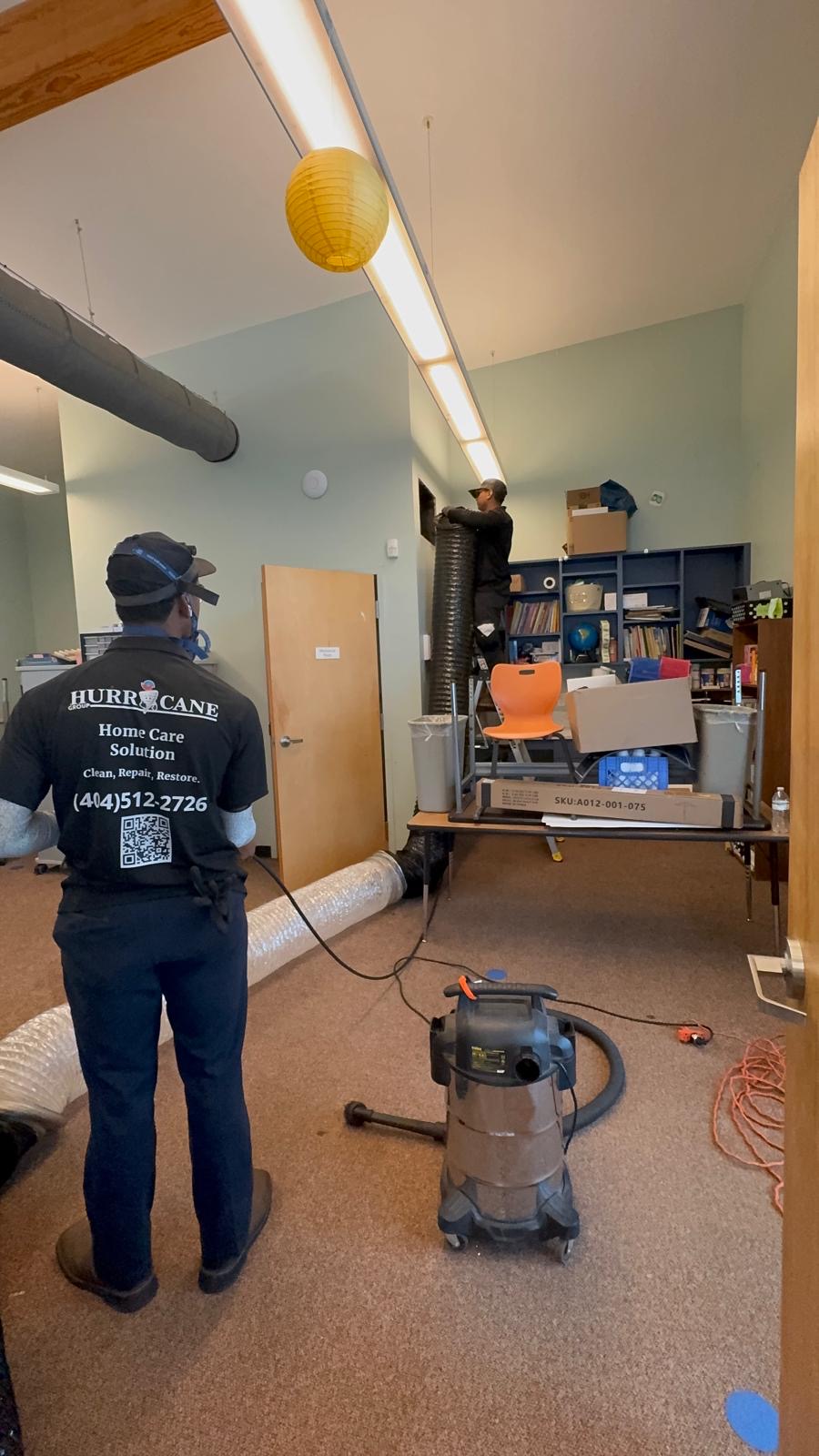 Negative air machine hose connected to a commercial trunk line during duct cleaning