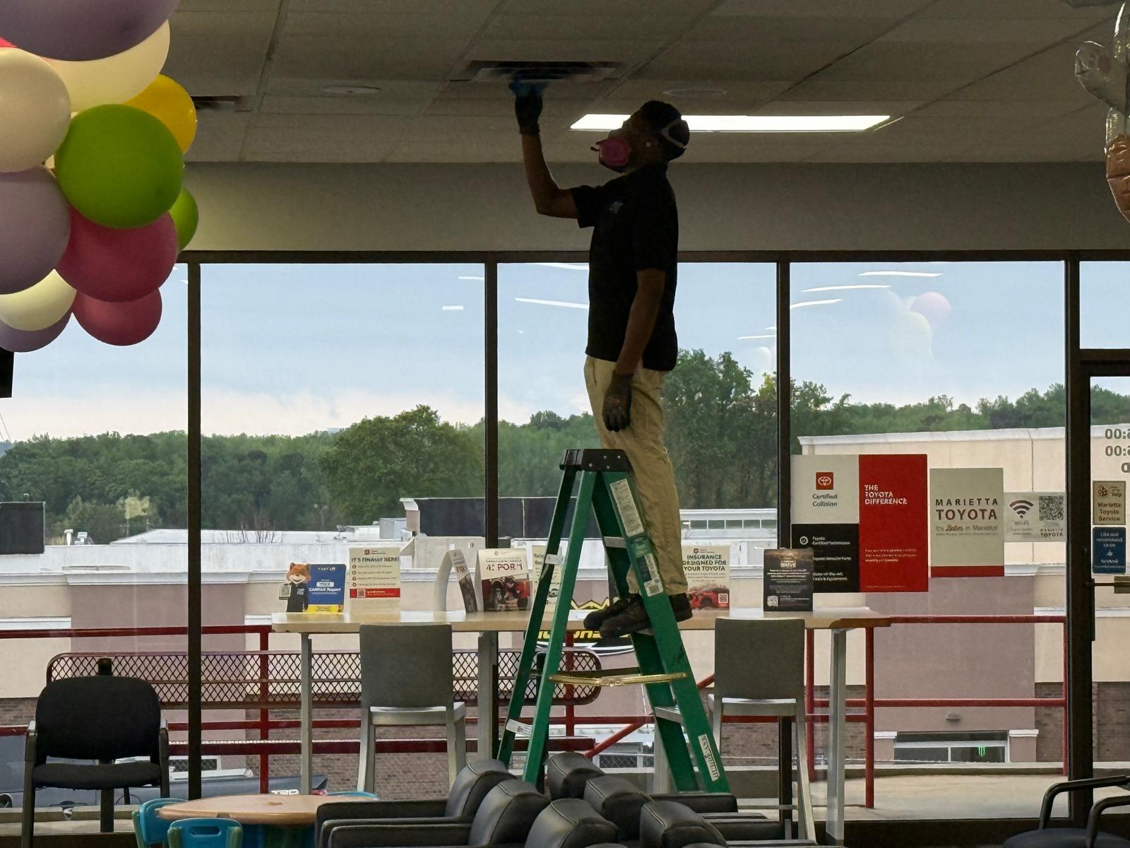 Toyota showroom window line — diffuser detail cleaning with respirator PPE