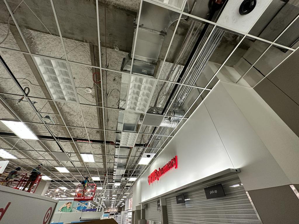 CVS pharmacy — open-grid ceiling exposing supply duct and flex runs above the counter