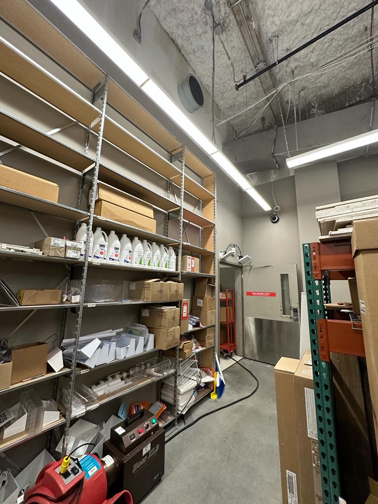 Stockroom HVAC — supply diffuser and overhead line check above storage shelving