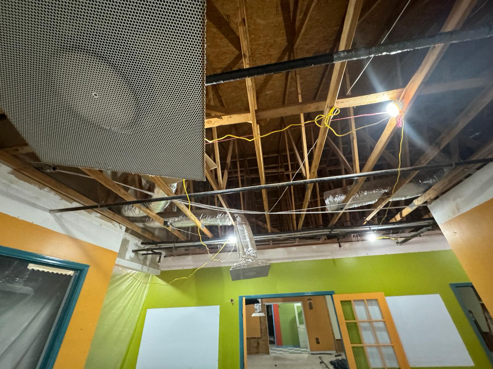 Build-out site — exposed trunk line and flex duct inspection above open framing