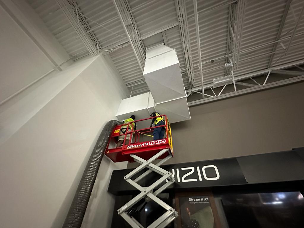 Electronics showroom — overhead supply duct cleaning from scissor lift