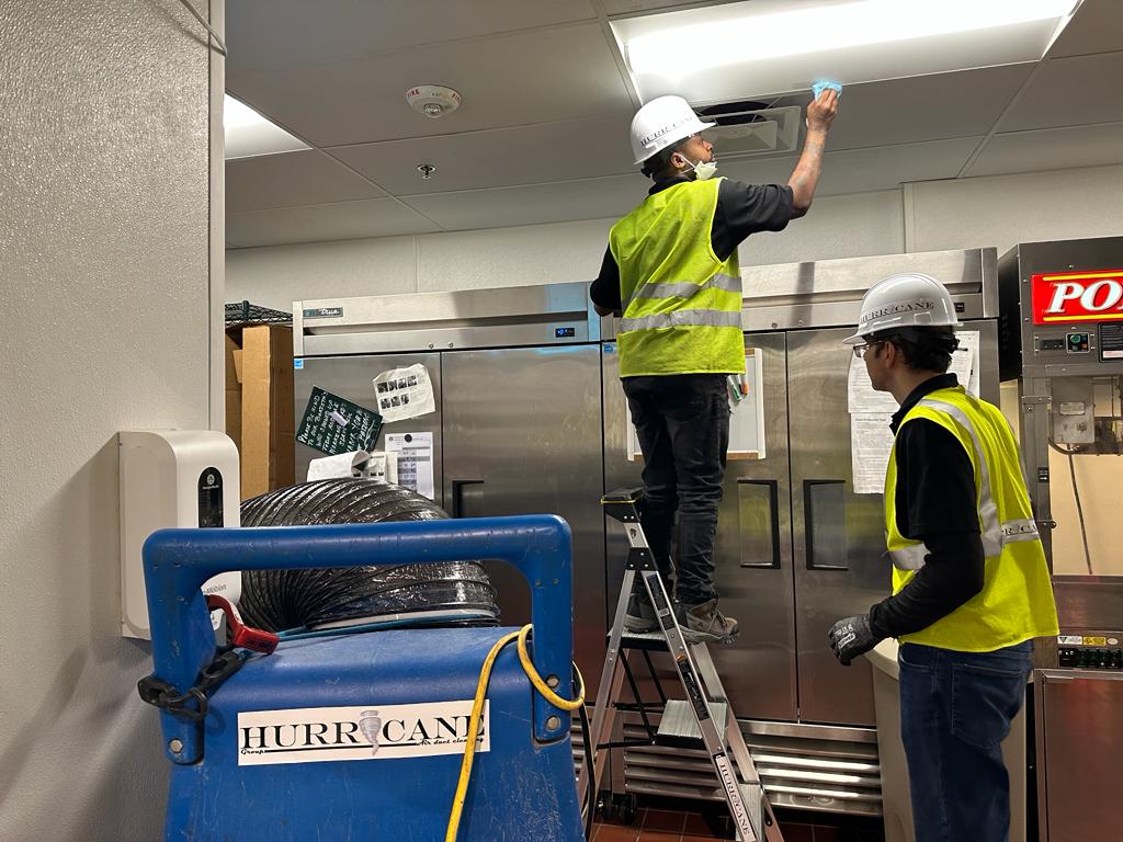 Restaurant kitchen — ceiling vent cleaning beside reach-in refrigeration